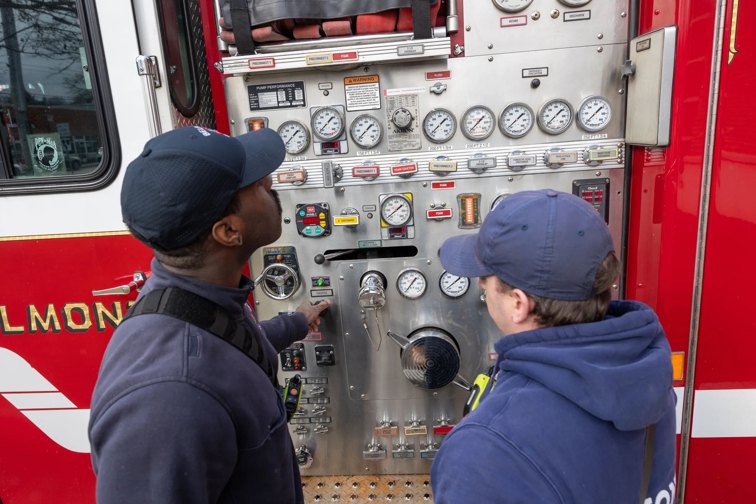 Firefighters Look at Gauges on Fire Truck